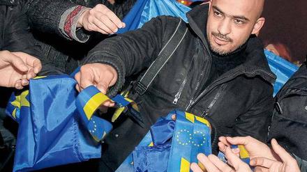 Pro-westlicher Protest. In der Ukraine demonstrierten Tausende gegen den Kurs der Regierung, der eine Annäherung an Russland vorsieht. Zu den Demonstranten gehörte auch ein Aktivist in Kiew, der Bänder in den Farben der EU verteilte. Foto: Gleb Garanich/Reuters