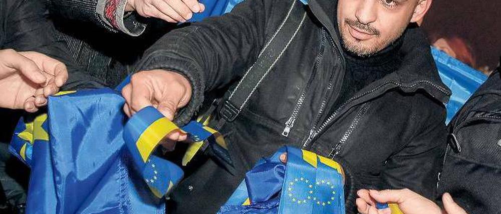 Pro-westlicher Protest. In der Ukraine demonstrierten Tausende gegen den Kurs der Regierung, der eine Annäherung an Russland vorsieht. Zu den Demonstranten gehörte auch ein Aktivist in Kiew, der Bänder in den Farben der EU verteilte. Foto: Gleb Garanich/Reuters