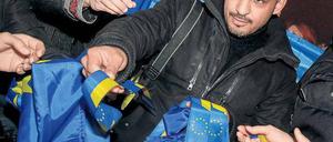 Pro-westlicher Protest. In der Ukraine demonstrierten Tausende gegen den Kurs der Regierung, der eine Annäherung an Russland vorsieht. Zu den Demonstranten gehörte auch ein Aktivist in Kiew, der Bänder in den Farben der EU verteilte. Foto: Gleb Garanich/Reuters