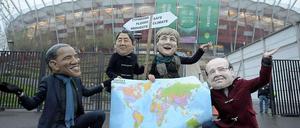 Vier Aktivisten der Entwicklungsorganisation Oxfam demonstrieren mit Pappköpfen wichtiger Staats- und Regierungschefs am Freitag vor dem Stadion in Warschau für ein besseres Klima. Tags zuvor war Oxfam mit dem WWF, Greenpeace und neun weiteren Organisationen demonstrativ aus dem Warschauer Gipfel ausgezogen. 