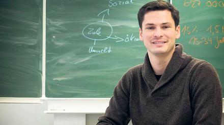 Niels Schirrmeister steht vor einer Tafel im Hörsaal der Technischen Universität.