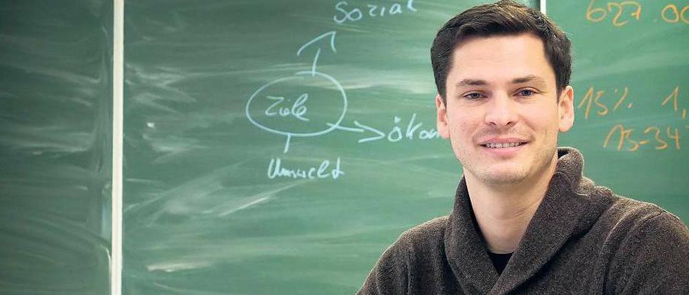 Niels Schirrmeister steht vor einer Tafel im Hörsaal der Technischen Universität.