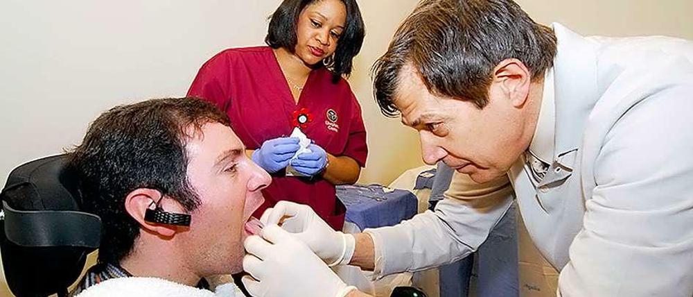 Patient bekommt Zungenpiercing, um seinen Rollstuhl zu lenken.