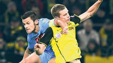 Begegnung der schmerzhaften Art. Sven Bender (rechts) stieß mit Neapels Christian Maggio zusammen und brach sich dabei das Nasenbein. Foto: Imago