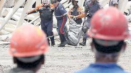 São Paulo unter Schock. Arbeiter beobachten die Bergung der toten Kollegen.