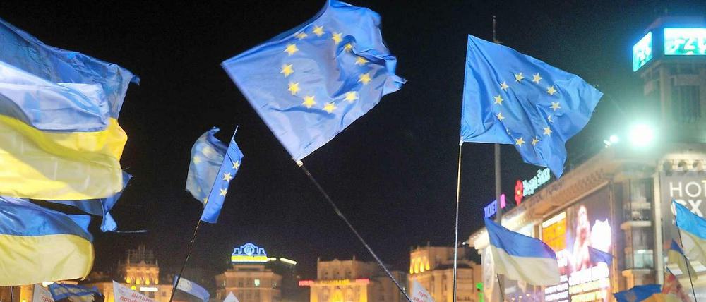 Demonstranten in Kiew schwenken die Fahnen der EU und der Ukraine. 