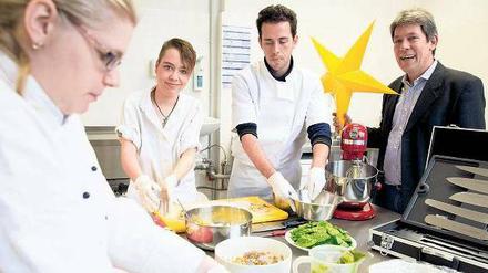 Kochkünstler. Mandy Ressel, 25, (l.) und Maika Bumenthal, 19, wissen, wie man richtig gute Pizzataschen zubereitet. Lehrer Emanuele Manciavillano gibt in der Lehrküche Tipps. Auch der zuständige ajb-Leiter Reinhold Kolkmann-Weisel dankt den Tagesspiegel-Lesern, die große Teile der Gastro-Einrichtung durch Spenden ermöglichten.