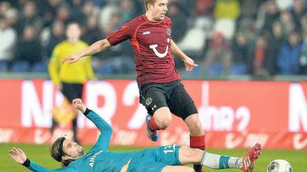 Langes Bein. Martin Lanig sah nach dieser Aktion gegen Hannovers Artur Sobiech Gelb-Rot. Am Ende verlor Frankfurt nicht nur Lanig, sondern auch das Spiel. Foto: dpa