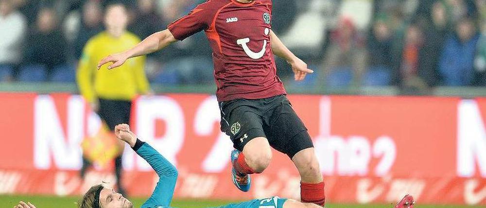 Langes Bein. Martin Lanig sah nach dieser Aktion gegen Hannovers Artur Sobiech Gelb-Rot. Am Ende verlor Frankfurt nicht nur Lanig, sondern auch das Spiel. Foto: dpa