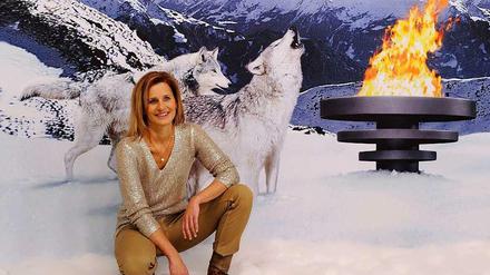 Kitsch mit Katrin Müller-Hohenstein. Die ZDF-Moderatorin posiert vor einem Werbeplakat für die olympischen Winterspiele in Sotschi.