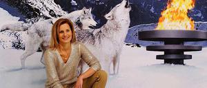 Kitsch mit Katrin Müller-Hohenstein. Die ZDF-Moderatorin posiert vor einem Werbeplakat für die olympischen Winterspiele in Sotschi.