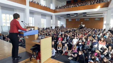 Eine Professorin spricht vor Studierenden im Hörsaal.