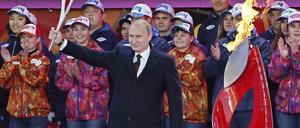 Russlands Präsident Wladimir Putin und das Olympische Feuer.