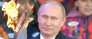 Feuer und Eis: Russlands Präsident Wladimir Putin trägt die Olympische Fackel