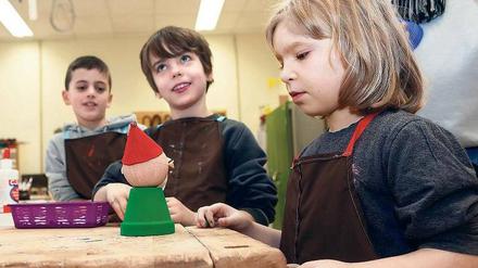 Kritischer Blick. Schüler der Treptower Bouché-Grundschule betrachten ihr Werk, das sie in den Lernwerkstätten in Oberschöneweide gebastelt haben. Foto: Georg Moritz