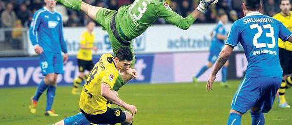 In der Schwebe. Das Publikum in Sinsheim sah ein rasantes Spiel mit vielen Möglichkeiten auf beiden Seiten, hier macht der ansonsten eher unsicher agierende Hoffenheimer Torwart Jens Grahl eine Chance der Dortmunder zunichte. Foto: AFP