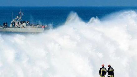 Verschluckt. Feuerwehrleute warten am Strand von Praia do Meco, draußen kreuzt die Küstenwache. 