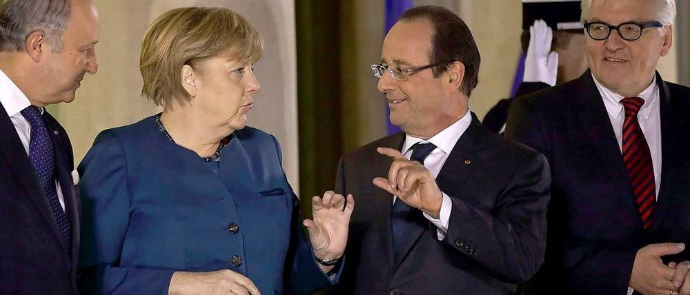 Treffen in Paris. Frankreichs Außenminister Fabius, Kanzlerin Merkel, Präsident Hollande und Bundesaußenminister Steinmeier (v. l.) vor dem Elysée-Palast.