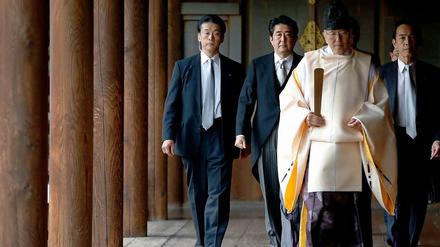 Umstrittener Besuch: Japans Premier Shinzo Abe (2.v.l.) lässt sich von einem Shinto-Priester zum Schrein führen