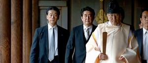 Umstrittener Besuch: Japans Premier Shinzo Abe (2.v.l.) lässt sich von einem Shinto-Priester zum Schrein führen