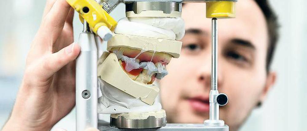 Kronen und Prothesen. Zahntechniker fräsen, gießen und reparieren. Foto: dpa