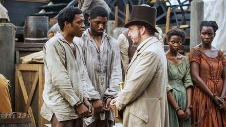 Gefangen. Salomon Northup (Chiwetel Ejiogfor, lks.) ist gekidnapt worden. Anderntags steht vor dem Sklavenhalter (Paul Giamatti).