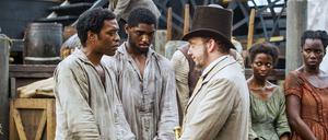 Gefangen. Salomon Northup (Chiwetel Ejiogfor, lks.) ist gekidnapt worden. Anderntags steht vor dem Sklavenhalter (Paul Giamatti).