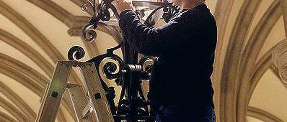 Auftritt. Während Hamburgs Bürgermeister am Donnerstag den Stromnetz-Deal vorstellte, tauschte ein Haustechniker in der Empfangshalle des Rathaus eine Lampe aus. Foto: dpa