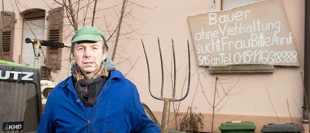 Der Bauer Roland Geiger vor seinem Brautschau-Plakat. 