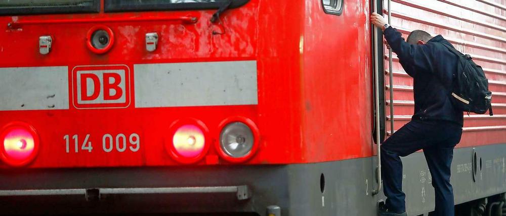 Ein Lokführer steigt von einer Lokomotive ab.