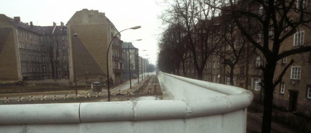 Berlin, einfach geteilt. Der Mauerstreifen zwischen Ost (links, Treptow) und West-Berlin (Neukölln). Harzer Straße Ecke Bouchéstraße, fotografiert im Jahr 1985.