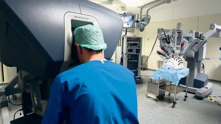 Fernbedienung. Der Operateur arbeitet an einer Konsole, die ihm ein 3-D-Bild des Operationsfeldes zeigt. Seine Aktionen werden – ohne Zittern – zu den Geräten auf dem OP-Tisch übertragen, um den Eingriff präzise auszuführen.