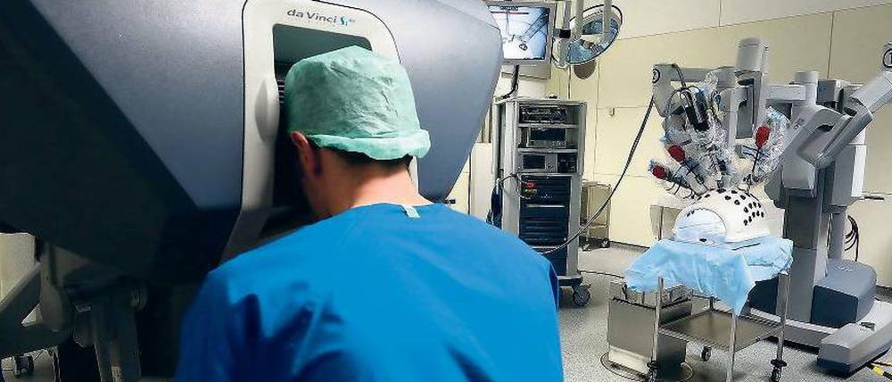 Fernbedienung. Der Operateur arbeitet an einer Konsole, die ihm ein 3-D-Bild des Operationsfeldes zeigt. Seine Aktionen werden – ohne Zittern – zu den Geräten auf dem OP-Tisch übertragen, um den Eingriff präzise auszuführen. 