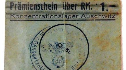 Bonuskarte. Auch dieser "Prämienschein über RM. 1.-Konzentrationslager Auschwitz", signiert mit Häftlingsnummer, steht zum Verkauf.