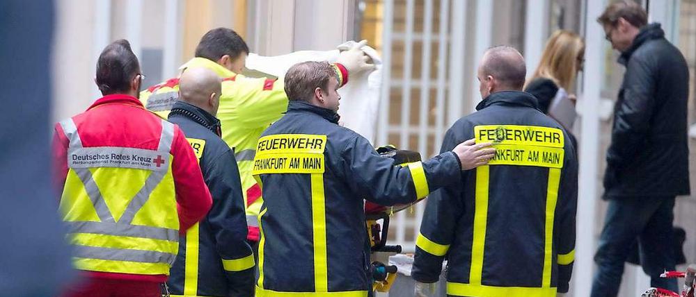 Sanitäter schirmen am Landgericht in Frankfurt am Main den Tatort ab. Im Eingangsbereich des Gebäudes hatte es eine Schießerei und eine Messerstecherei gegeben.
