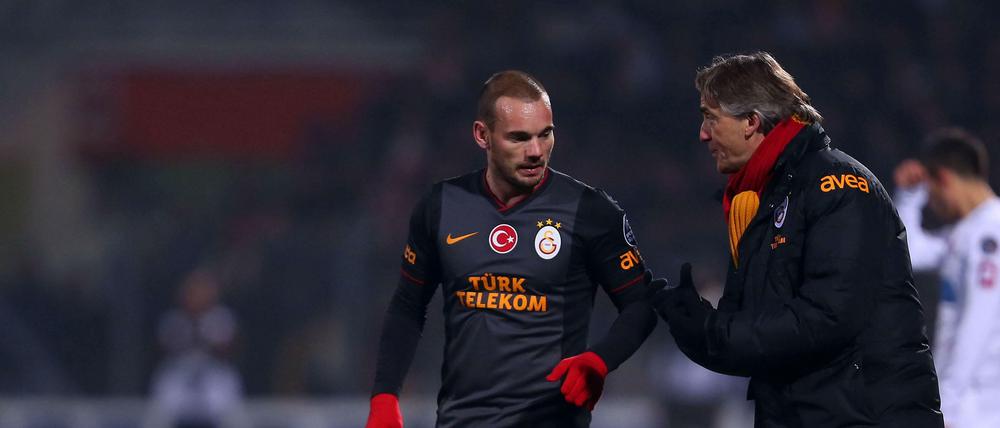 Internationales Flair: Zu viele Ausländer wie Wesley Sneijder (l.) darf Roberto Mancini (r.) aber nicht im Kader haben.