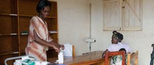 Ruanda. Eine Ärztin in einer ländlichen Arzneiausgabe gibt Medizin an Patientin aus.