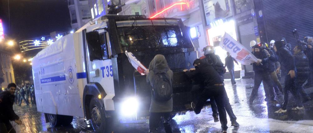Mensch gegen Maschine. Demonstranten in Istanbul attackieren ein mit einem Wasserwerfer ausgerüstetes Fahrzeug der Polizei in Istanbul.