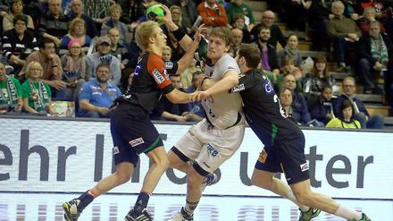 Berlins Kreisläufer Jesper Nielsen kämpft sich durch zwei Magdeburger.