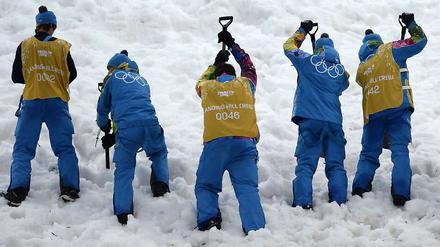 Völlig versulzt. Helfer kämpfen mit dem Kunstschnee von Sotschi.