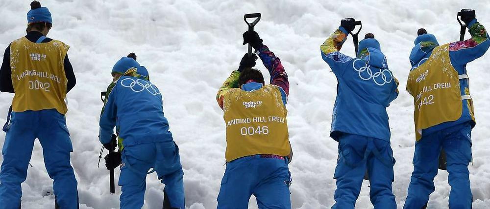 Völlig versulzt. Helfer kämpfen mit dem Kunstschnee von Sotschi.
