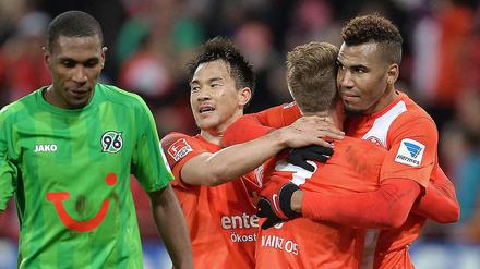 Der Mainzer Maxim Choupo-Moting (r.) jubelt nach seinem Tor mit seinen Teamkollegen Niki Zimling (2.v.r.) und Shinji Okazaki. Links Hannovers enttäuschter Marcelo.