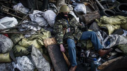 Ein Demonstrant ruht sich hinter den Barrikaden nahe des Maidan aus. 
