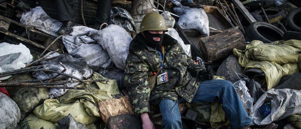 Ein Demonstrant ruht sich hinter den Barrikaden nahe des Maidan aus.