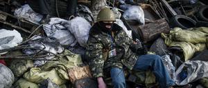 Ein Demonstrant ruht sich hinter den Barrikaden nahe des Maidan aus.