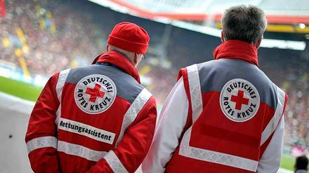 Zwei Rettungssanitäter beim Einsatz während eines Fußballspiels.