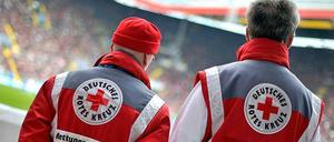 Zwei Rettungssanitäter beim Einsatz während eines Fußballspiels.