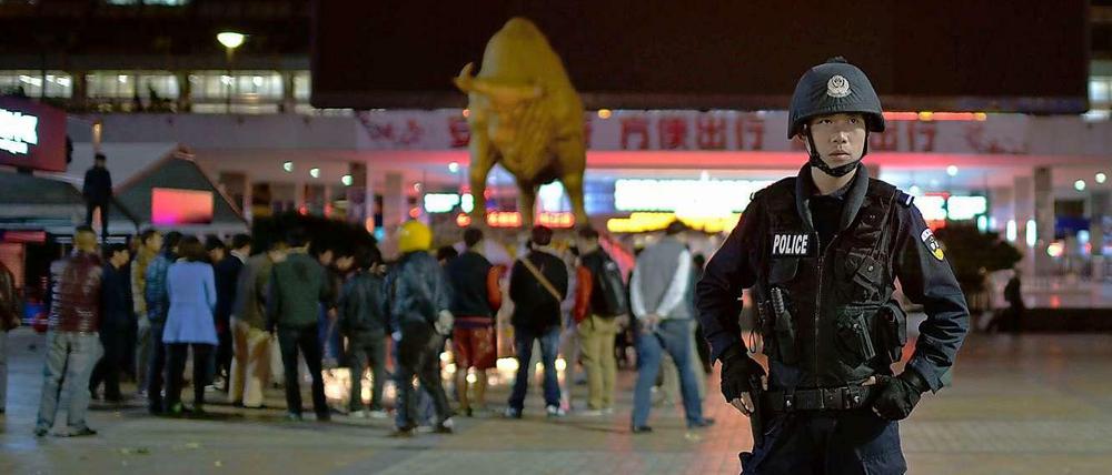 Nach dem Blutbad stehen Trauernde und Polizisten vor dem Bahnhof in Kunming.