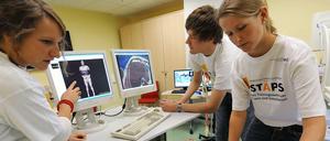 Medizinstudierende üben eine Untersuchungsmethode an einer Patientenpuppe.