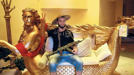 Prunk und Punk: Ein Milizionär auf Meerjungfrauensofa in einem der Paläste von Libyens Diktator Gaddafi 